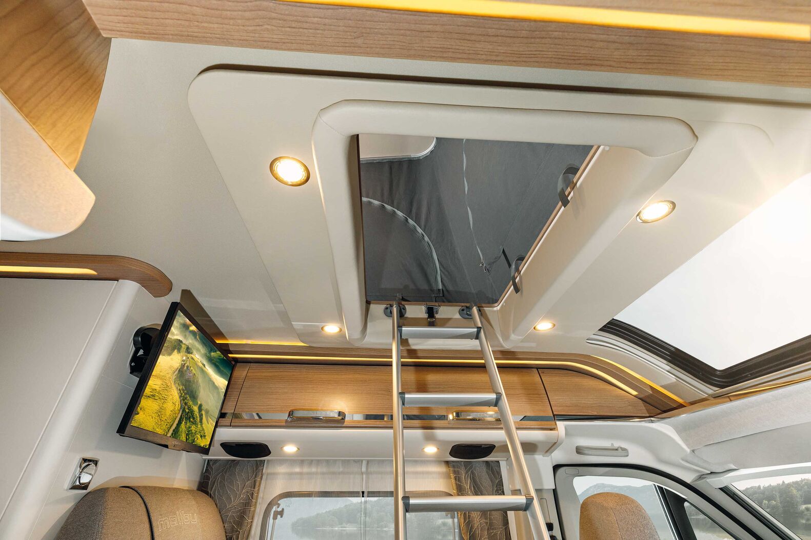 Malibu Van family-for-4 : Un maximum d’espace pour les familles avec enfants, les couples avec leurs petits enfants ou les vacances entre amis : le van Malibu family for 4 offre deux grandes chambres. Malibu a développé et fabriqué lui-même son toit relevable exclusif conçu selon une méthode de sandwich hybride. Cette méthode comprend un revêtement de toit « Protect » en GFK pour protéger le véhicule de la grêle et des dommages extérieurs. La structure du toit séduit par une isolation en mousse rigide RTM et un plafond intérieur en aluminium. Un revêtement respirant en microfibres à l’intérieur du toit crée une atmosphère agréable. Une cinématique habile basée sur des compas aux pieds et des ressorts à gaz à l’avant soulève le toit lors de l’ouverture, tandis que le large angle de bascule offre un grand espace pour la tête. En haut, un grand lit de 200 x 135 cm est équipé d’un matelas en mousse haute densité de qualité. Le toit relevable est disponible pour de nombreux vans Malibu en version family for 4.