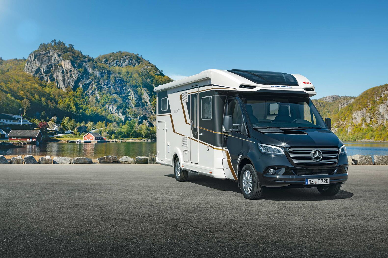 Eura Mobil Contura sur Mercedes-Benz : Il suffit d’un coup d’œil depuis l’extérieur pour comprendre que le Contura sur Mercedes-Benz vise le haut de gamme. Cela se manifeste notamment par sa forme, avec des bordures de phares affirmées et des raccords plats entre la cabine et la cellule moderne en GFK. La méthode de fabrication moderne RIM donne par ailleurs la garantie d’une précision absolue. Pour la transition avec la cellule aussi, Eura Mobil ne s’est pas contenté d’une solution standard. L’habillage du plafond se fond précisément dans la géométrie de la cabine, de manière à offrir un passage particulièrement large et confortable et beaucoup d’espace pour la tête.