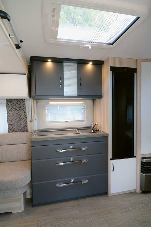 La cuisine gris foncé séduit d’emblée et offre tout l’équipement requis, y compris un éclairage fonctionnel et des prises 230 V.