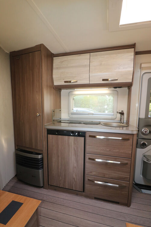 La cuisine compacte dotée d’un réfrigérateur 106 l offre deux tiroirs, un compartiment à trappe et deux grandes armoires suspendues.