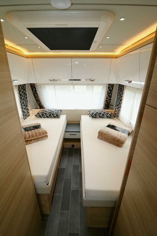 Chambre confortable avec des lits jumeaux agréables, qu’il est possible de séparer du reste de l’espace avec une porte coulissante en bois.