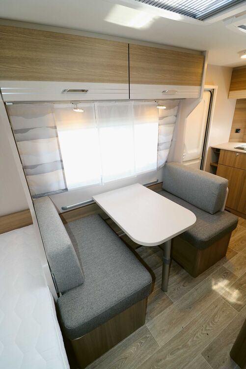 L’aménagement intérieur, avec les coloris bois chauds, l’effet parquet au sol et le design des rideaux et coussins, crée une ambiance agréable.