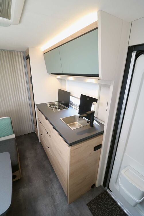 Dotée de nombreux éléments d’éclairage, la cuisine familiale offre un grand plan de travail et un espace de rangement suffisant dans l’armoire suspendue et le placard inférieur.