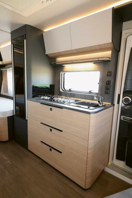 La cuisine claire plaît d’emblée avec ses éléments sombres, tandis que les nombreuses sources d’éclairage et les éléments de design viennent compléter cette image positive.