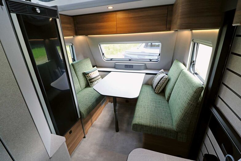 L’intérieur mêlant des teintes de gris et des surfaces textiles et en bois crée une ambiance chaleureuse, soulignée par les nombreuses sources de lumière.