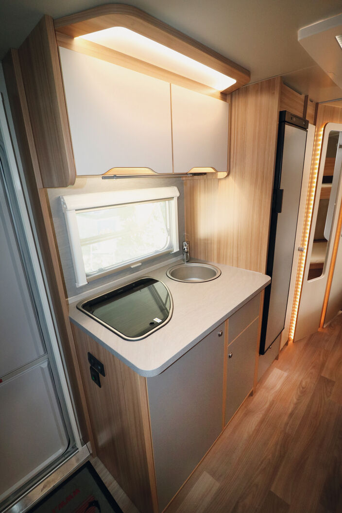 Compacte, la cuisine offre suffisamment d’espaces de rangement ainsi qu’un grand réfrigérateur.