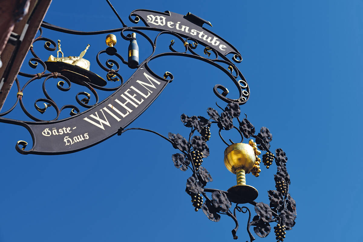 Schmiedeeiserne Wirtshausschilder, wo wie hier das Besteck schon im Braten steckt, verheissen leckere und opulente pfälzische Kochkünste.
