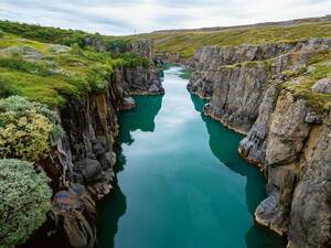 Langsam fliesst das grün-bläuliche Wasser im Moira Canyon, direkt an der Ringstrasse im Osten.