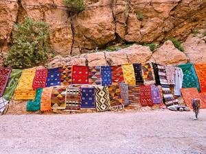 Vendeurs de tapis dans les gorges du Todra: des chefs-d’œuvre tissés à la main au milieu des imposantes parois rocheuses.