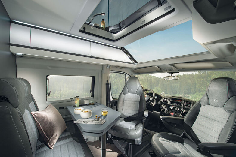 Une dînette de fourgon classique avec sièges de cabine pivotants.