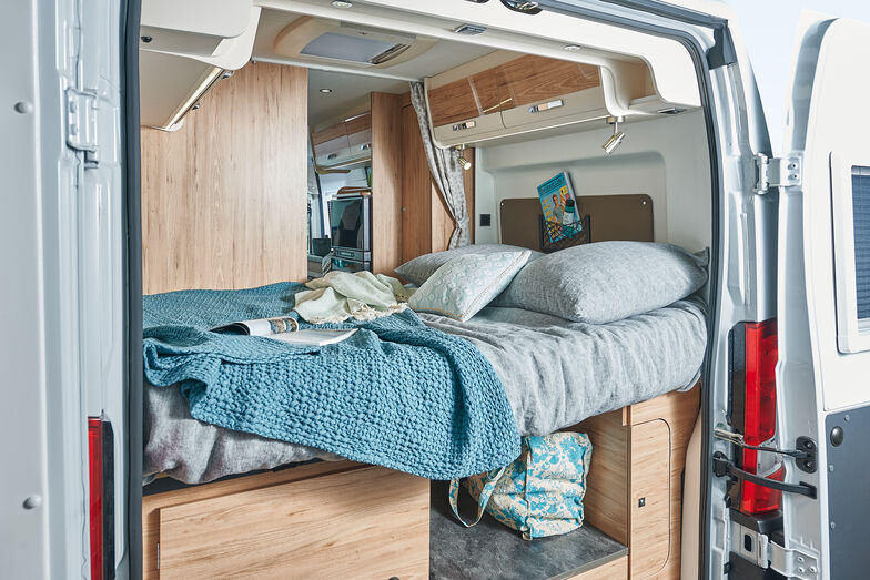 Le lit double est installé à l'arrière. En dessous, il y a beaucoup de place de rangement.