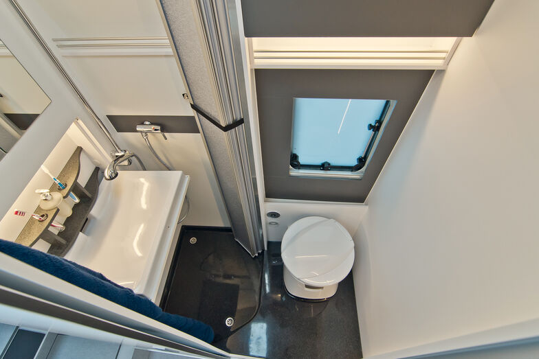 Si le lavabo est relevé en position de rangement, il laisse place à la douche.