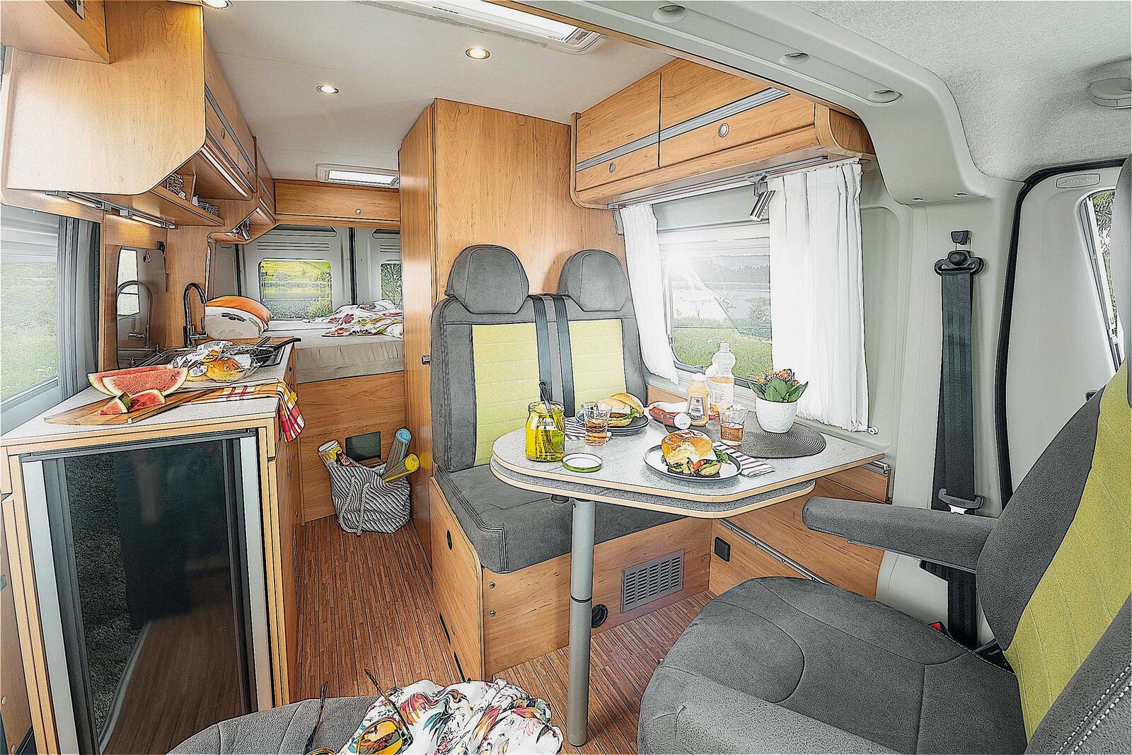 Vue sur la dînette, la cuisine et la salle de bains devant le lit double à l’arrière.