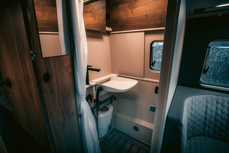 Toilette sèche coulissante et lavabo rabattable.