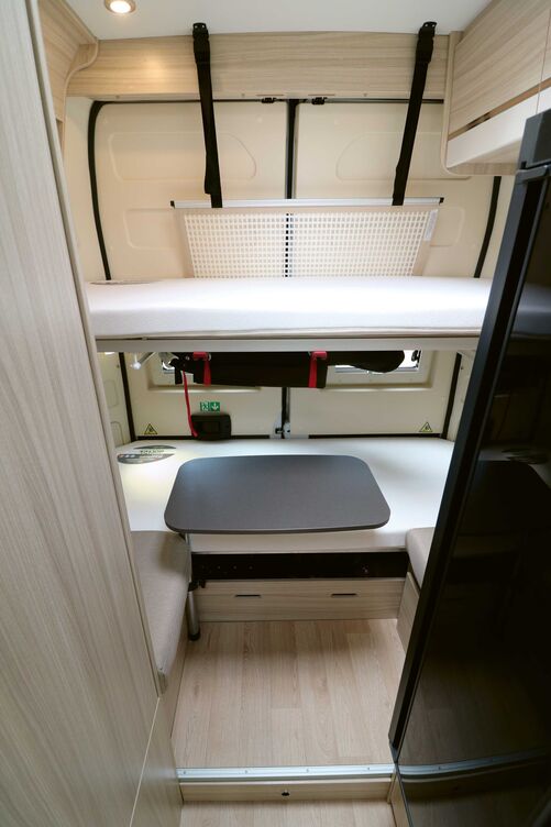 Chambre pour enfants avec deux lits et banquettes face à face.