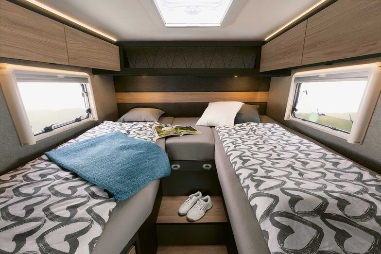 Dethleffs Globebus Performance 4x4 avec lits jumeaux à l’arrière et beaucoup d’espace de rangement en dessous.