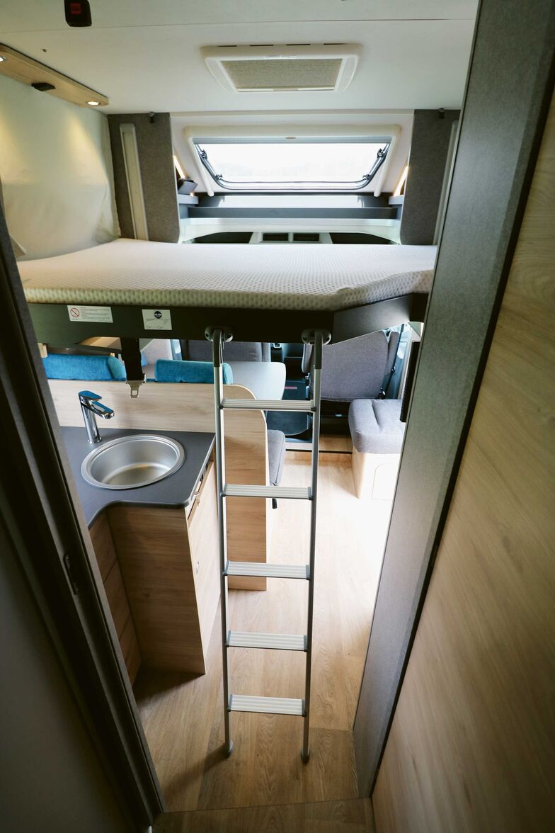 Un système électrique permet de lever ou d’abaisser facilement le lit placé sur des rails. Le couchage dépasse malheureusement dans l’entrée.