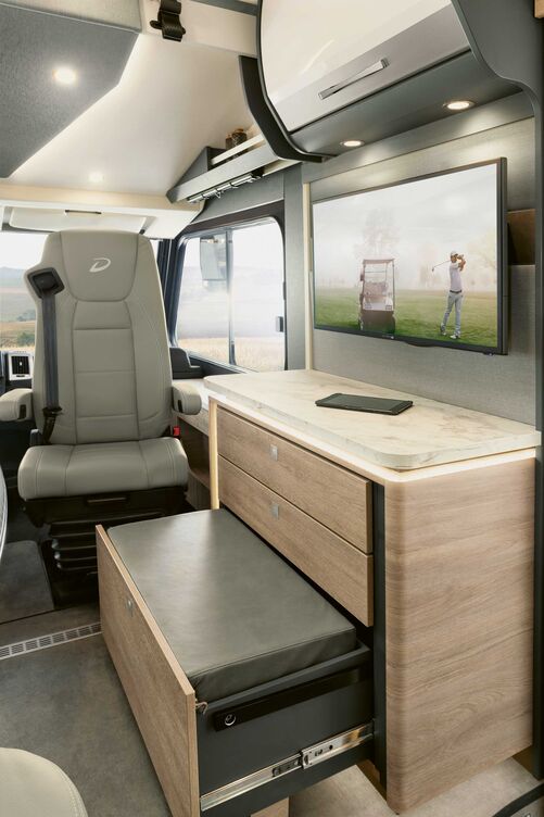 Ce tiroir peut servir de marchepied pour accéder au lit ou de repose-pieds pour le passager. Un espace de rangement se trouve sous le rembourrage.