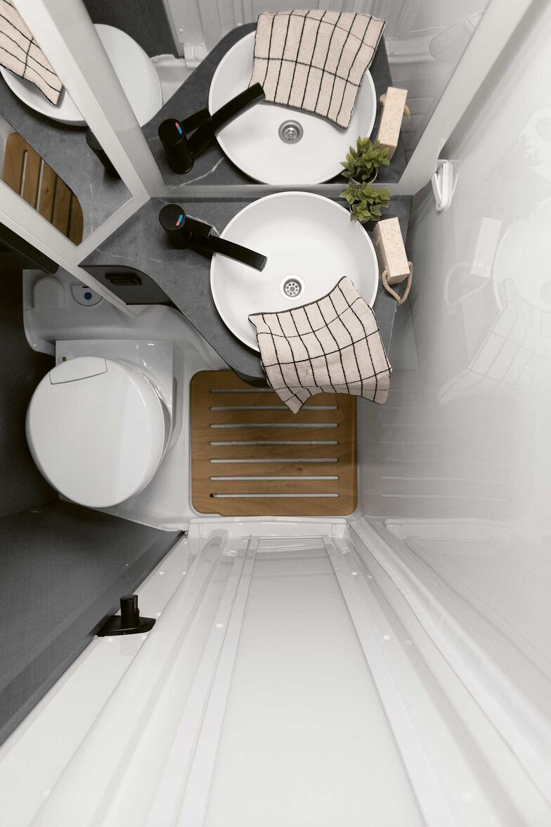 Grâce à une paroi pivotante, l’espace W.C. se transforme en cabine de douche.