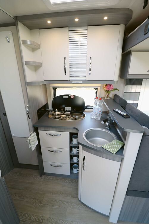 La cuisine entièrement équipée répond à toutes les attentes avec un comptoir, une plaque de cuisson trois feux, un profond évier rond, un porte-serviettes, des niches de rangement et de nombreux rangements.