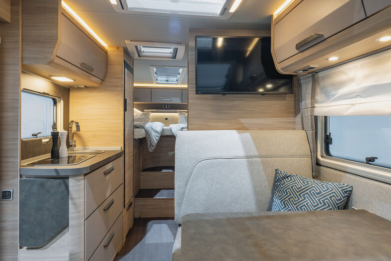 Vue depuis la cabine sur la kitchenette et ses grands tiroirs, avec la chambre à coucher en arrière-plan.