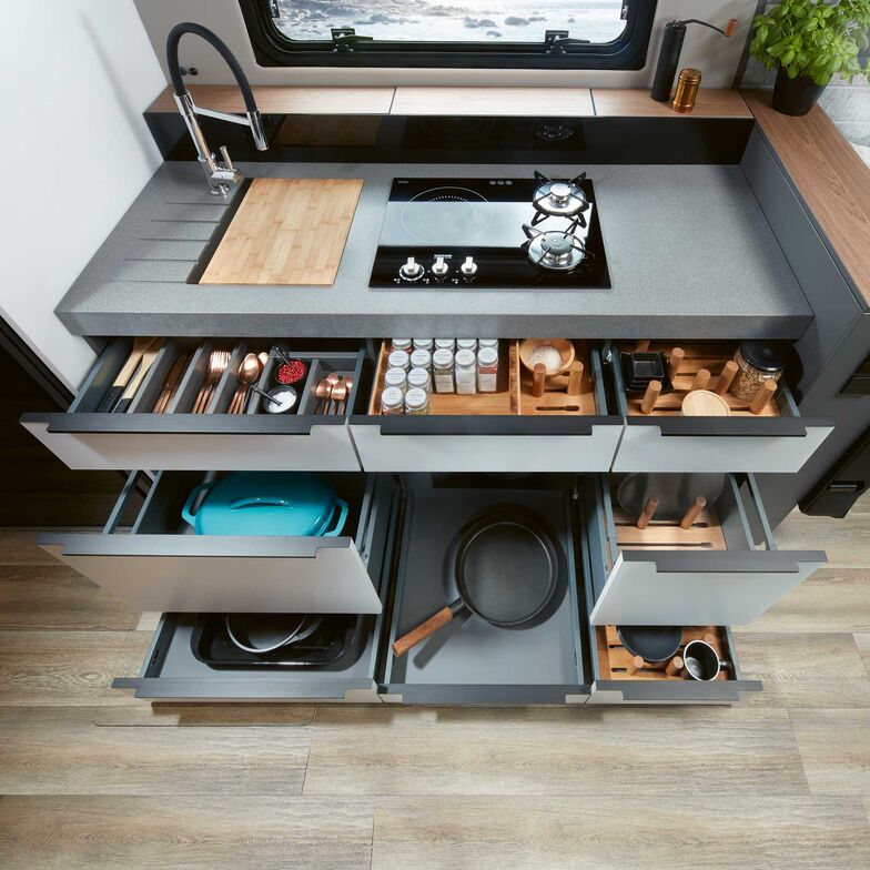 La cuisine possède deux plaques au gaz et une à induction. Une hotte d’aspiration au déploiement électrique peut également être obtenue en option.