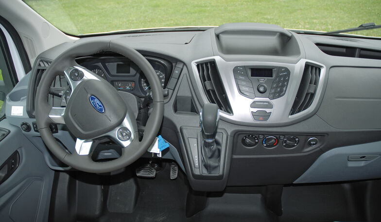 Cabine avec volant et levier de vitesses en cuir.