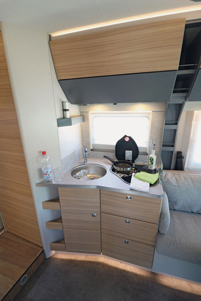 Avec le placard bas présentant un léger angle, la cuisine fonctionnelle et accueillante offre suffisamment de place pourle rangement et un plan de travail satisfaisant.