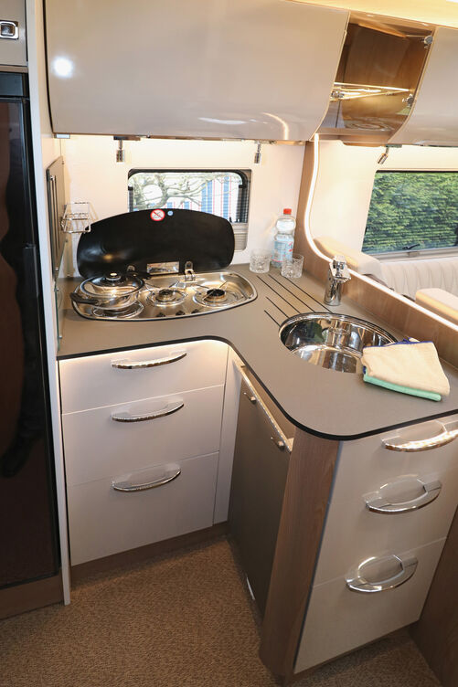 Cuisine élégante avec de nombreux espaces de rangement et sources de lumière.